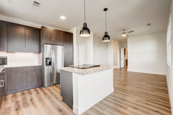 A kitchen with a white island and dark brown cabinets.